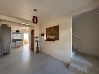 Hall de entrada com piso de cerâmica e parede de destaque em madeira.