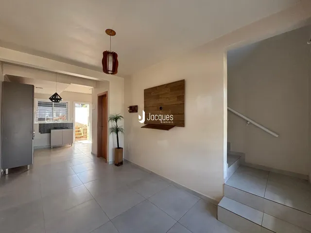 Hall de entrada com piso de cerâmica e parede de destaque em madeira.