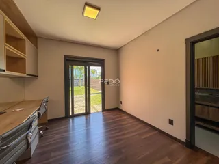 Sala de estar com piso de madeira e porta de vidro abrindo para o jardim.