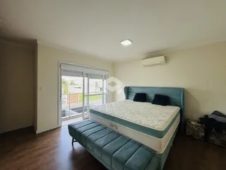 Quarto com cama e porta de vidro dando para o quintal.