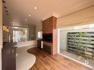 Sala de estar com piso de madeira e parede de destaque de tijolos.