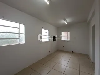 Uma sala interna com paredes brancas e piso de cerâmica.