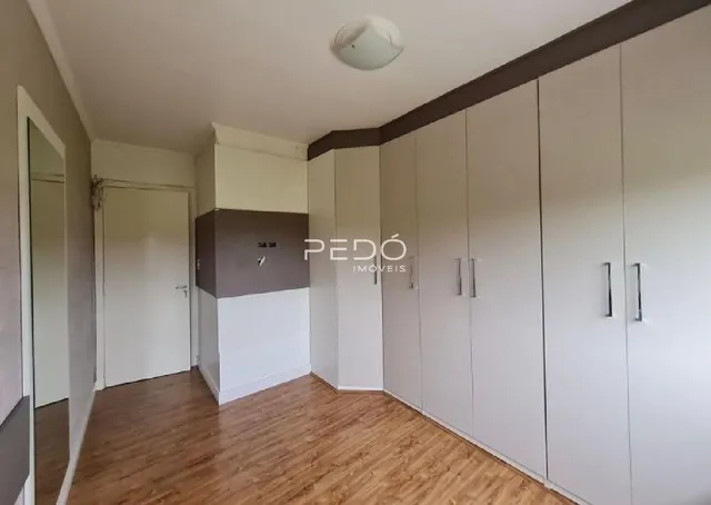 Interior de um corredor com armários embutidos e piso de madeira clara.