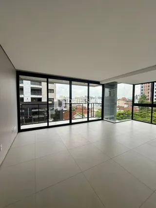 Sala de estar com grandes janelas de vidro que dão vista para o exterior.