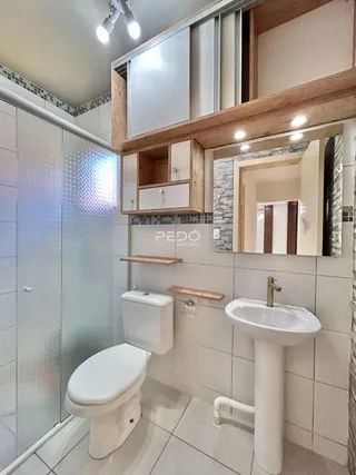 Foto de um banheiro com revestimento de azulejos brancos e bancada branca.