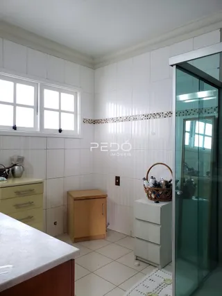 Vista interna de uma sala com paredes brancas e detalhes de painel decorativo.
