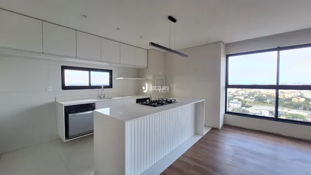 Cozinha moderna com armários brancos e ilha em um apartamento.
