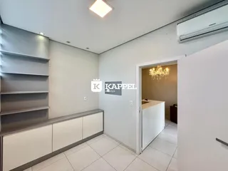 Sala de estar com estantes e piso claro.