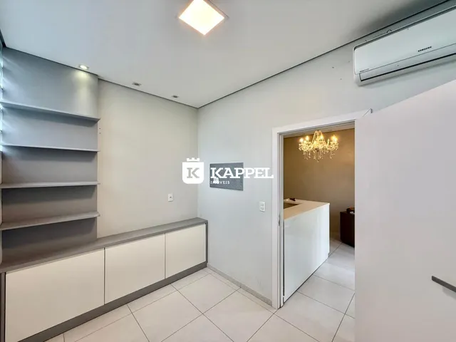 Sala de estar com estantes e piso claro.