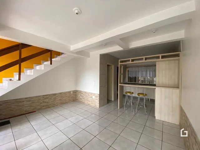 Foto de uma área interna com piso de cerâmica e escadaria em um imóvel.