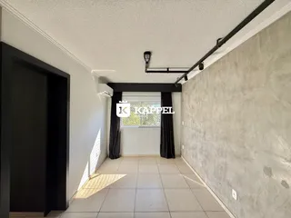 Hall de entrada com piso de cerâmica e janela coberta por cortinas escuras.