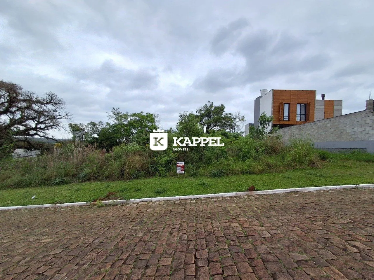 Vista externa de uma propriedade em Lajeado, Brasil, mostrando o edifício e a área gramada.
