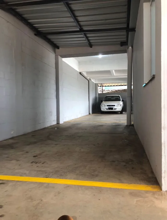 Foto de um corredor interno com piso de concreto e estrutura metálica.