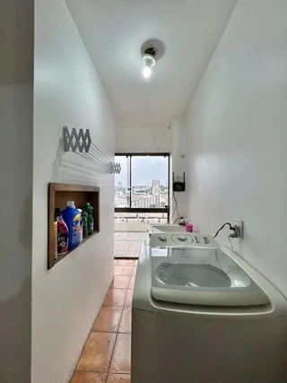 Hall de corredor com piso de cerâmica e vista da cidade.