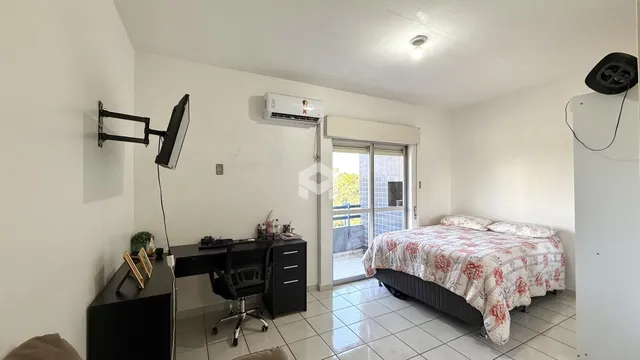 Quarto com cama e escrivaninha em ambiente claro.