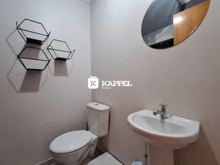 Foto de um banheiro interno mostrando um vaso sanitário e uma pia brancas.