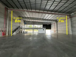 Espaço interno amplo com piso de concreto e estrutura metálica.