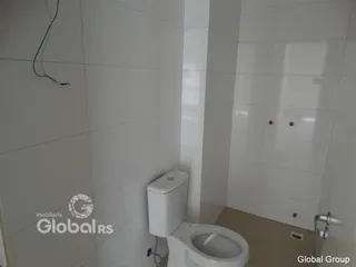 Foto de um banheiro com paredes brancas e azulejos.