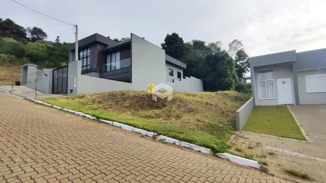 Fachada de uma residência moderna em Lajeado, Brasil, com jardim em primeiro plano.