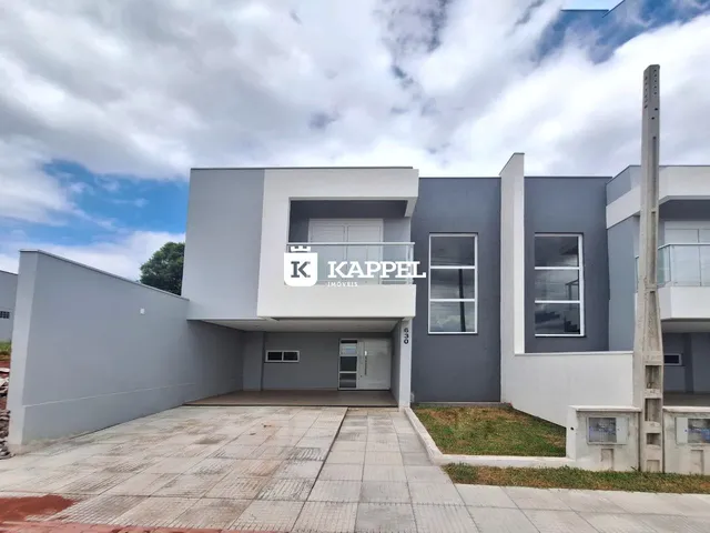 Fachada moderna de um prédio residencial em Lajeado, Brasil, com detalhes em branco e cinza.