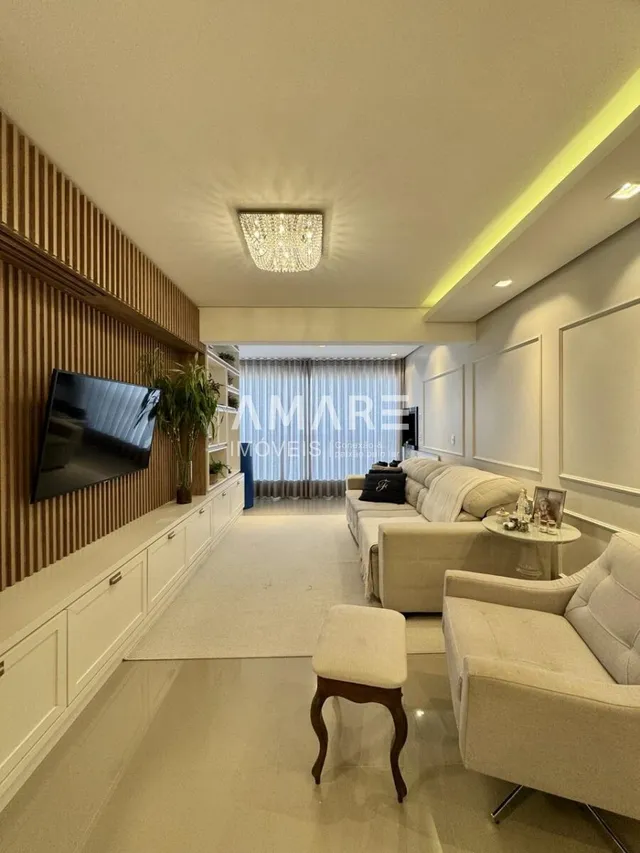 Sala de estar com painel de madeira e sofá claro.
