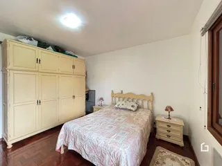 Quarto com armários e cama em madeira clara.