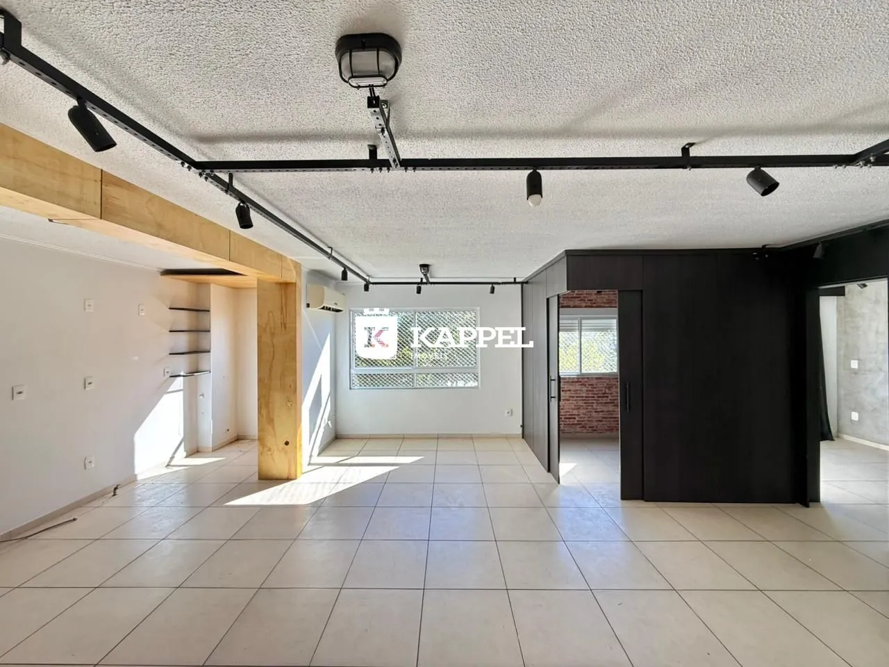 Ambiente interno amplo com piso de cerâmica e estrutura de madeira aparente.