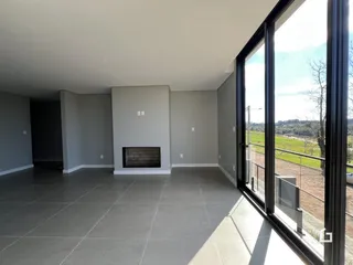 Sala de estar moderna com grande janela para a paisagem.