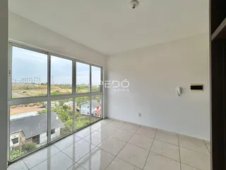 Sala com grandes janelas que oferecem vista para a paisagem externa.