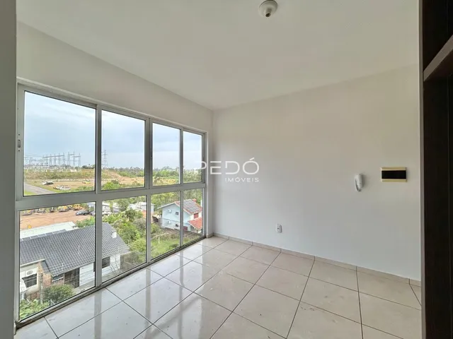 Sala com grandes janelas que oferecem vista para a paisagem externa.