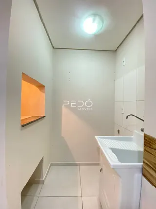 Foto de um banheiro interno com revestimento branco e piso claro.