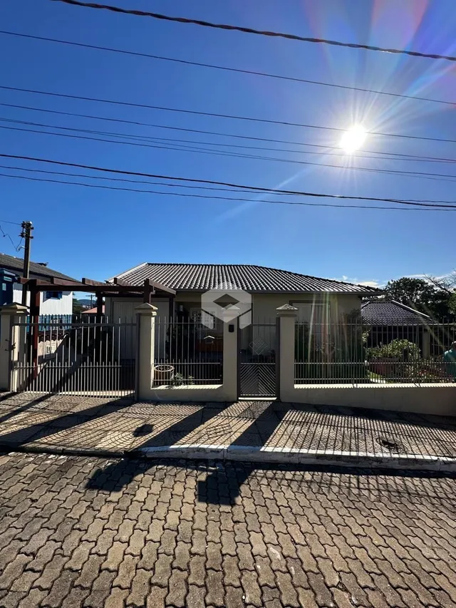 Fachada de uma residência em Lajeado, Brasil, com cerca e portão.