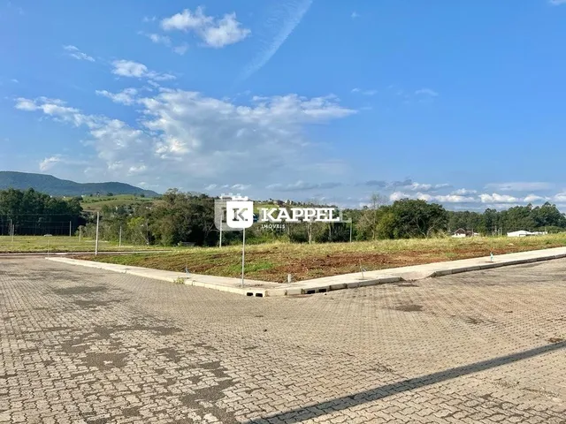 Vista externa de um terreno pavimentado com paisagem de colinas ao fundo.