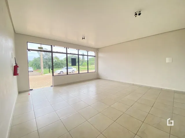 Sala de estar com piso de cerâmica e portas de vidro que dão para o exterior.