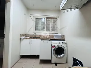 Uma cozinha com máquina de lavar roupa e armários brancos.