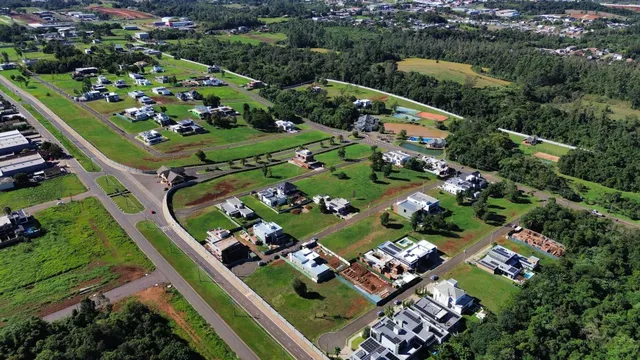 Vista aérea de um loteamento residencial com ruas e áreas verdes em Lajeado, Brasil.