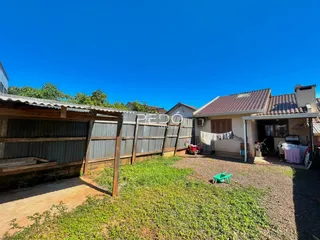 Vista externa de uma propriedade em Lajeado, Brasil, com cerca e jardim.
