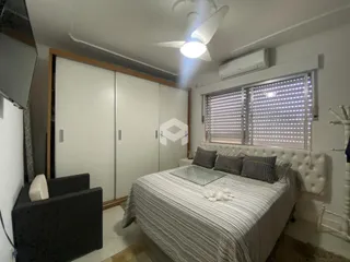 Quarto com cama e armário branco em um imóvel no Brasil.