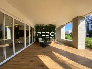 Sala de estar com piso de madeira e vista para o exterior.