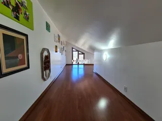 Hall de entrada com piso de madeira no interior da residência.