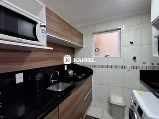 Foto de uma cozinha com bancada escura e revestimento de azulejos brancos.