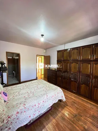 Quarto com cama e armário de madeira escura.