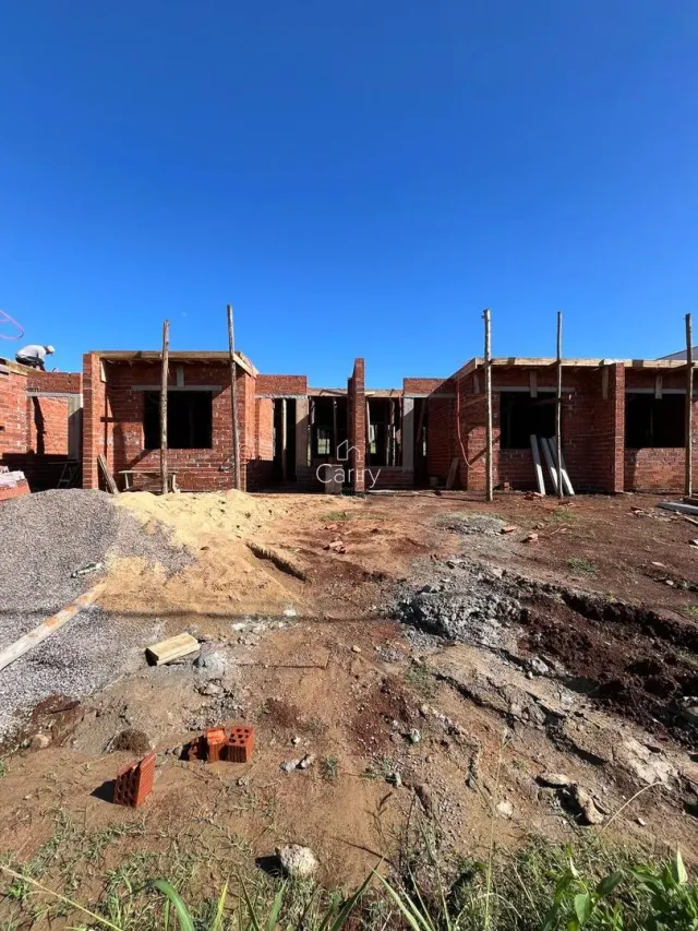 Foto de um canteiro de obras com estrutura de tijolos exposta.