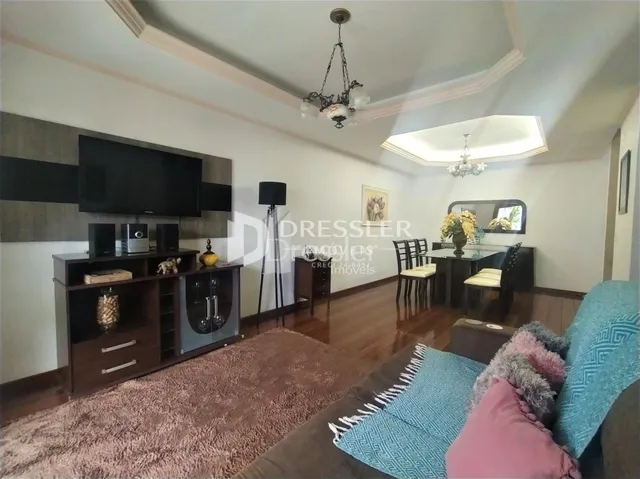 Sala de estar com parede clara e móveis de madeira escura.