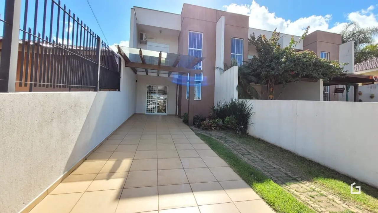 Fachada de uma residência em Lajeado, Brasil, com muro branco e piso de cerâmica.