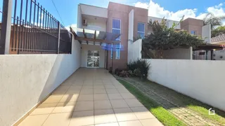 Fachada de uma residência em Lajeado, Brasil, com muro branco e piso de cerâmica.