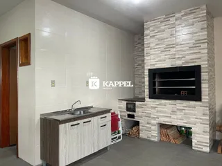 Foto de uma cozinha com armários e lareira de pedra em um imóvel.
