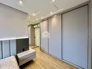 Interior de um quarto com armários embutidos e piso de madeira.