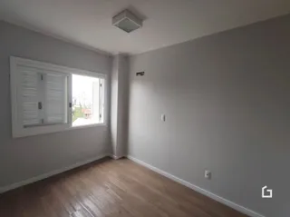 Ambiente interno de uma sala com piso de madeira clara.