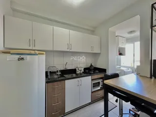 Foto da cozinha com armários brancos e bancadas escuras.